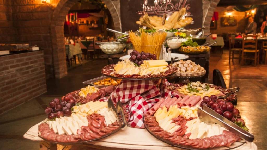 A gastronomia italiana também tem espaço no roteiro A presença italiana é outro elemento importante da formação cultural da Serra Gaúcha. Massas, polentas, galetos, vinhos, queijos e outras receitas ligadas à imigração aparecem em diferentes experiências gastronômicas da região. Entre as opções oferecidas pela JE Hoffmann está a Noite Italiana, que pode ser incorporada ao roteiro de quem deseja transformar o jantar em mais uma experiência da viagem. Inclusive, combinar diferentes noites gastronômicas é uma forma interessante de conhecer um pouco das culturas que influenciaram a região sem ocupar os períodos reservados aos passeios durante o dia.